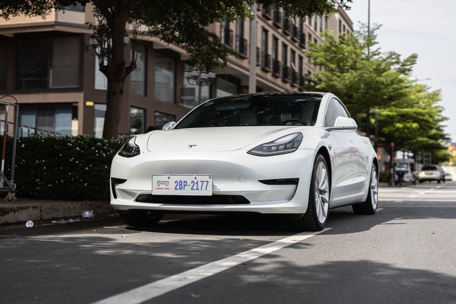 Afbeelding van verschillende modellen kleine elektrische auto's en scootmobielen in een stedelijke omgeving.